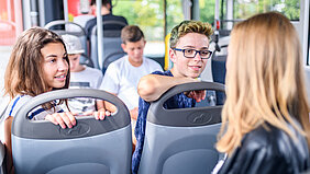 Eine Gruppe Schülerinnen und Schüler unterhält sich im Bus.