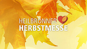 Nahaufnahme von gelb-orangem Herbstlaub, davor das Logo der Heilbronner Herbstmesse.