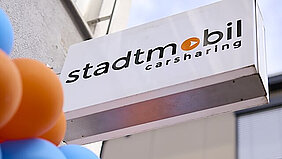 weißes Schild mit stadtmobil-Logo über dem Eingang zum Servicebüro